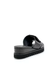 Black leather mule with jewel accessory. Leather lining, leather covered wedge a